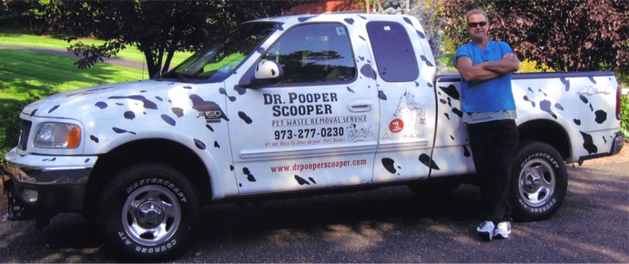 Owner Richard Roy standing next to his white Dr Pooper Scooper Truck